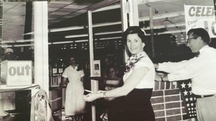 Mildred Shaddock cuts the ribbon opening Shaddock's Rainbow Supermarket in Lake Jackson, Texas.