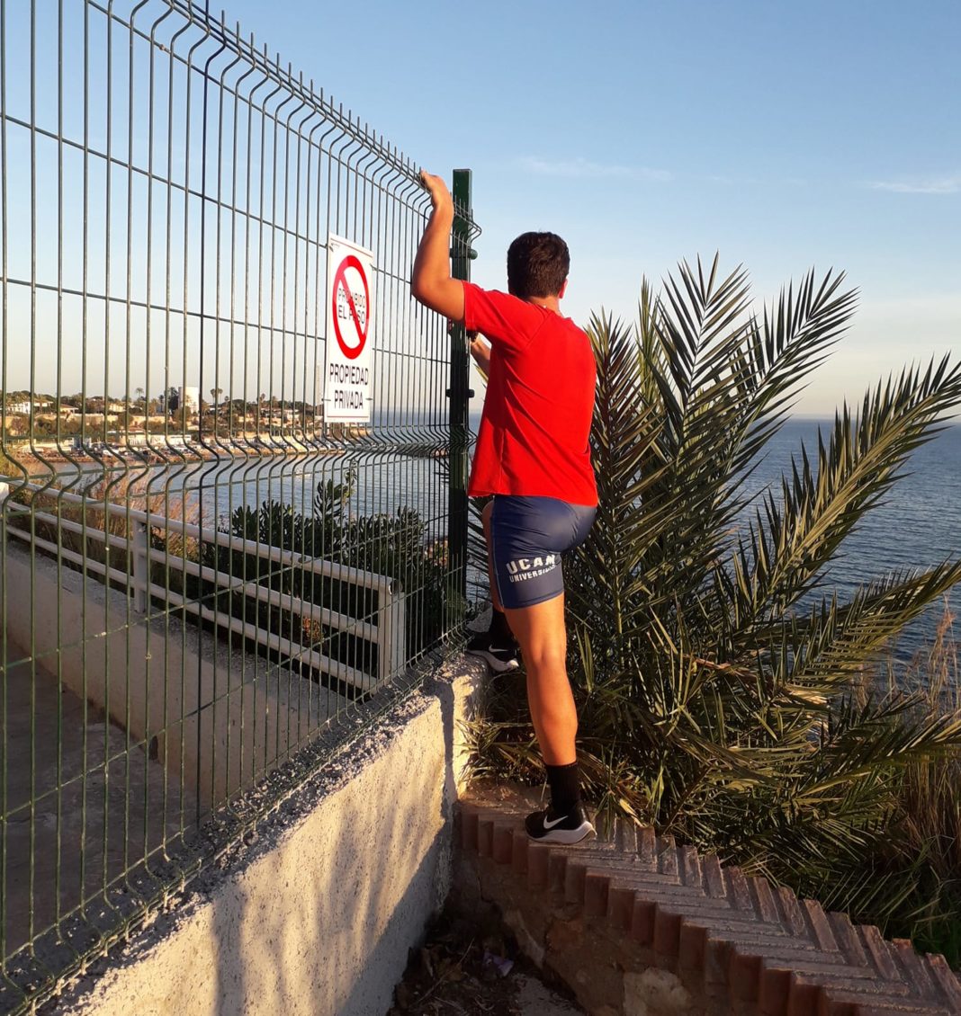 A resident puts his life at risk by climbing around the fence